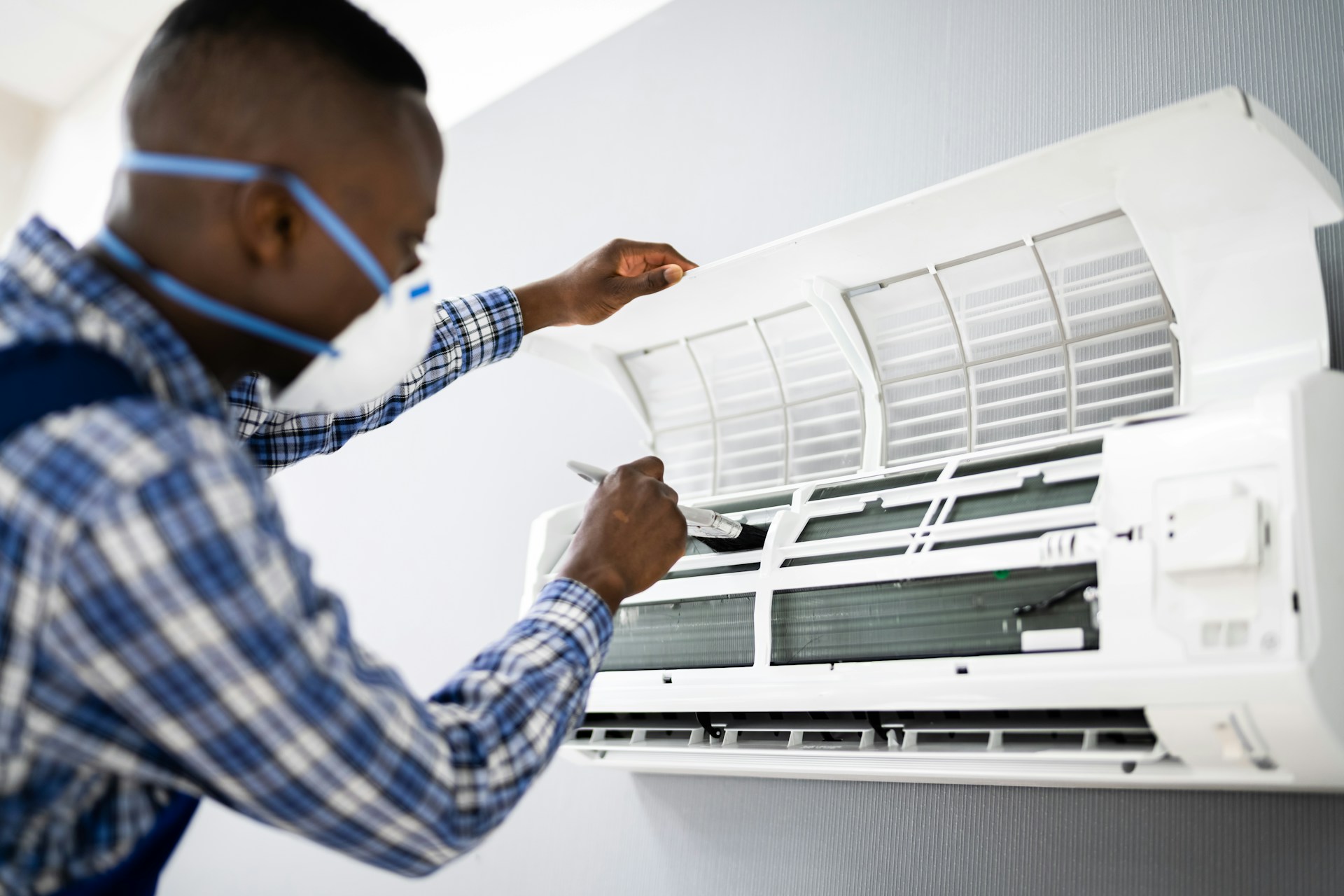 HVAC Blog 2 Technician performing maintenance on an air conditioning unit, emphasizing the importance of regular AC tune-ups for home comfort.